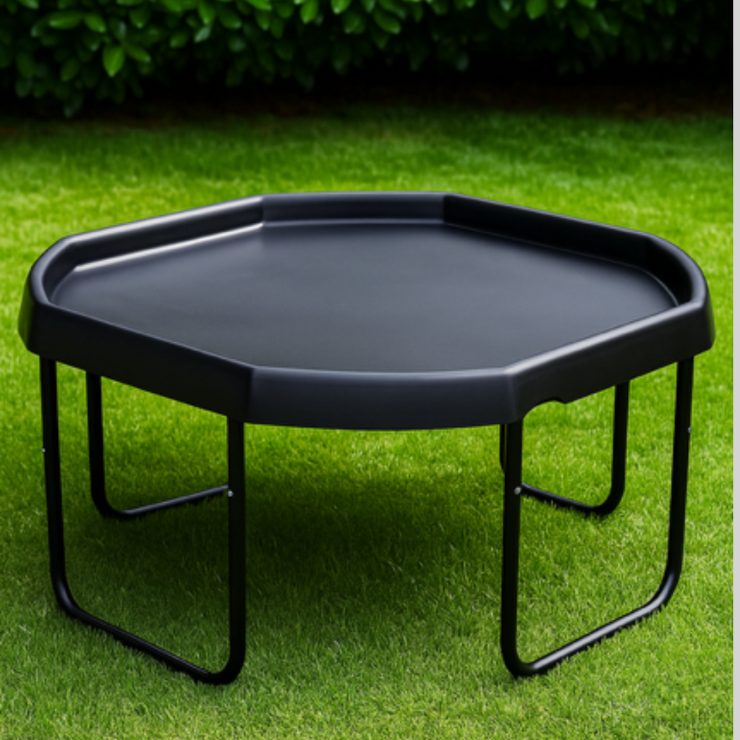Tuff tray stand with black tuff tray, photographed on green grass with dark foliage in the background.